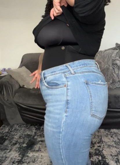 Depois, de lado na calça jeans: barriga reta, sem sobra no cós